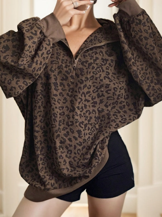 Leopard print poncho worn by a person against a neutral background